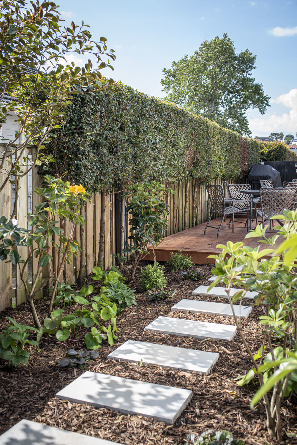 Stepping pavers through mulch leading to deck and seating